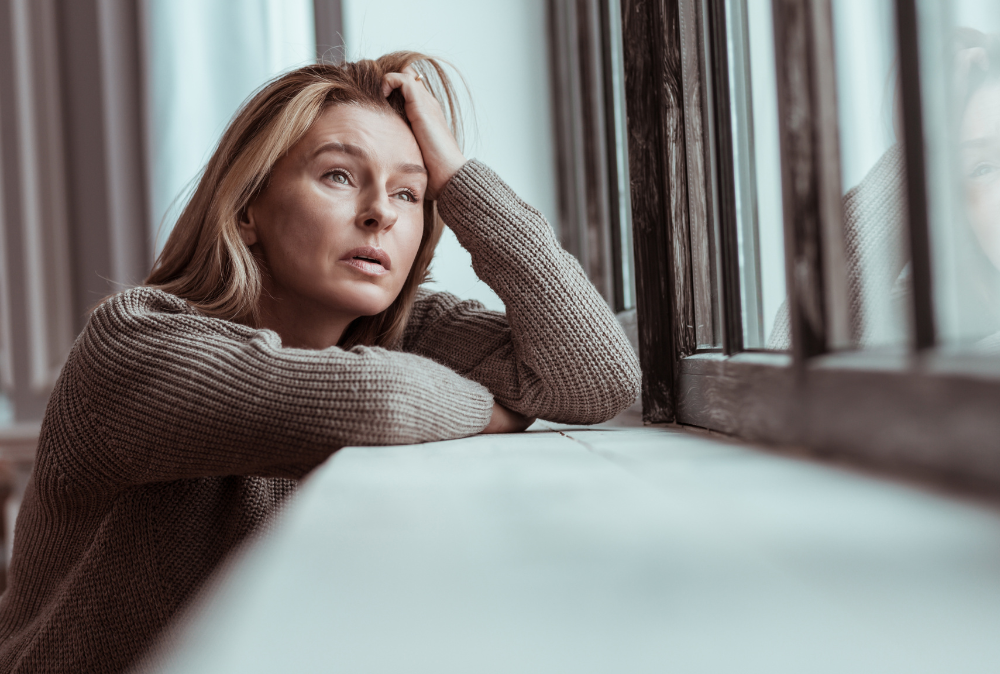 woman sad looking out the window, seasonal depression